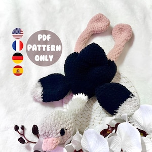 May include: A handmade crochet ostrich toy in black, white, and pink. The ostrich has a black body, pink legs, and white accents. The image includes the text "PDF PATTERN ONLY" in a circular design with flags.