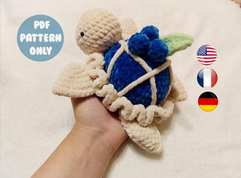 May include: Crochet pattern for a plush toy turtle with a blue shell and a green leaf. The pattern is available in English, French, and German.