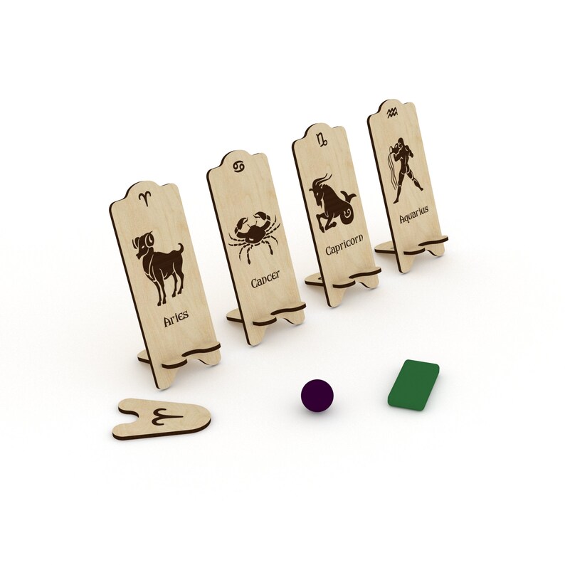 May include: Wooden zodiac sign stands with the symbols for Aries, Cancer, Capricorn, and Aquarius. The signs are made of light brown wood and have black ink.