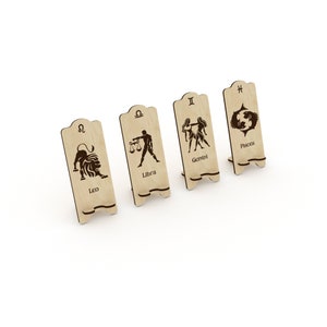 May include: Four wooden signs with zodiac symbols and names: Leo, Libra, Gemini, and Pisces. Each sign has a small stand on the back.