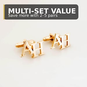 Op de afbeelding: Goudkleurige manchetknopen met de letters "AH" in een schreeflettertype. De manchetknopen worden gepresenteerd op een witte achtergrond. De bovenkant van de afbeelding heeft een banner met de tekst "MULTI-SET VALUE" en "Save more with 2-5 pairs".