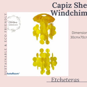 Può includere: Un carillon di conchiglie di capiz giallo con una cima rotonda e più strati di conchiglie. Il carillon misura 30 cm per 70 cm. Il testo "Etcheteras Handmade Gifts" è visibile nell'immagine.