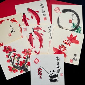 K&ouml;nnte beinhalten: Eine Sammlung quadratischer Gru&szlig;karten mit Illustrationen in roter und schwarzer Tinte. Die Karten zeigen Kois, Blumen und einen Panda. Rote Umschl&auml;ge sind sichtbar. Einige Karten haben chinesische Schriftzeichen.