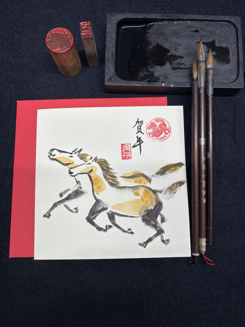 May include: An artistic composition featuring a watercolor painting of two running horses, accompanied by calligraphy brushes, ink, a stone ink well, and two wooden stamps. The painting has a red border.