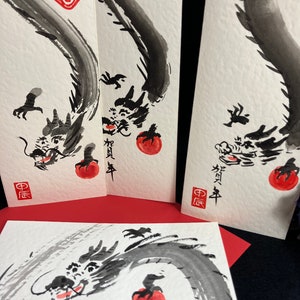 Puede incluir: Tres pinturas de tinta negra de un drag&oacute;n con un c&iacute;rculo rojo en su boca. El drag&oacute;n est&aacute; enroscado alrededor del c&iacute;rculo. Las pinturas est&aacute;n sobre papel blanco con caracteres chinos rojos. Los caracteres en la pintura m&aacute;s a la izquierda son "中庸". Los caracteres en la pintura del medio son "新年". Los caracteres en la pintura m&aacute;s a la derecha son "新年".