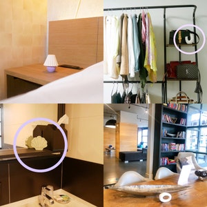 May include: A white ceramic shell-shaped object with a ridged surface, displayed on a dark shelf next to a black tissue box, serving as a decorative accent piece in a room setting with neutral tones and clean lines.
