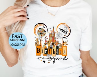 May include: White t-shirt with a Halloween-themed Mickey Mouse ears design featuring a castle, characters, and the text "Birthday Squad".