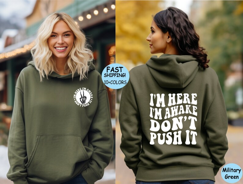 May include: A green hooded sweatshirt with the text "I'm here I'm awake Don't push it" printed in white on the back. The front of the sweatshirt has a small circle with a peace sign and the text "I'm here I'm awake Don't push it" printed in white.