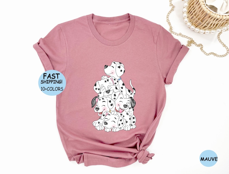 Puede incluir: Camiseta de color malva con una ilustraci&oacute;n de cachorros d&aacute;lmatas apilados con manchas negras. Los cachorros est&aacute;n sonriendo. La camiseta tiene el texto "FAST SHIPPING! 10+ COLORS" en un c&iacute;rculo azul.
