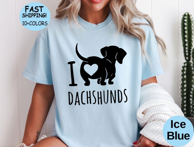 May include: A light blue t-shirt with a black dachshund silhouette and the text "I love dachshunds".