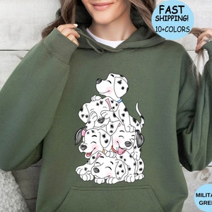 Puede incluir: Sudadera con capucha verde militar con una ilustraci&oacute;n de cachorros d&aacute;lmatas apilados. Los cachorros tienen manchas negras y est&aacute;n sonriendo. La sudadera tiene una capucha con cord&oacute;n y un bolsillo delantero. El texto "FAST SHIPPING! 10+ COLORS" est&aacute; en un c&iacute;rculo azul.
