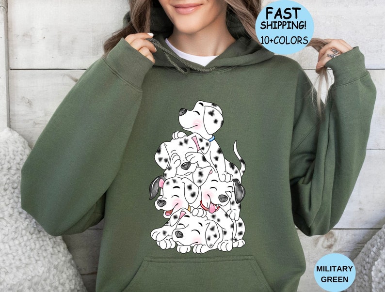 Puede incluir: Sudadera con capucha verde militar con una ilustraci&oacute;n de cachorros d&aacute;lmatas apilados. Los cachorros tienen manchas negras y est&aacute;n sonriendo. La sudadera tiene una capucha con cord&oacute;n y un bolsillo delantero. El texto "FAST SHIPPING! 10+ COLORS" est&aacute; en un c&iacute;rculo azul.