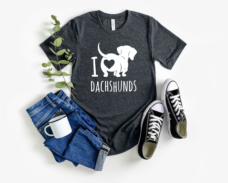 May include: A dark gray t-shirt with a white silhouette of a dachshund with a heart in its rear end and the text "I love dachshunds".