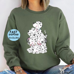 Puede incluir: Sudadera verde oliva con una ilustraci&oacute;n de dibujos animados de cachorros d&aacute;lmatas. Los cachorros est&aacute;n apilados, con manchas negras y caras sonrientes. La sudadera tiene el texto "FAST SHIPPING! 10+ COLORS" y "MILITARY GREEN" en las mangas.