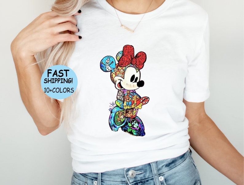 May include: White t-shirt featuring a colorful graphic of Minnie Mouse with a red bow. The graphic is filled with various Disney characters. Text on the shirt reads "FAST SHIPPING! 10+ COLORS".