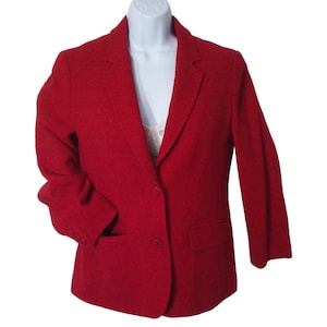 May include: A red blazer with a single-breasted closure and two button accents. The blazer has a pocket on the left side and long sleeves.