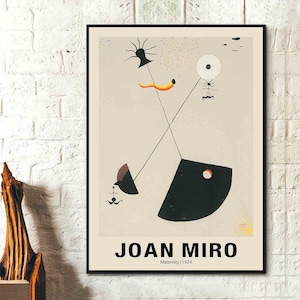 Puede incluir: Una impresión de arte abstracto en blanco y negro con fondo beige. La impresión presenta un círculo negro con un punto blanco en el centro, una forma negra con un punto rojo y una forma negra con un punto marrón. La impresión también presenta una figura negra similar a una araña, una figura negra y naranja similar a un gusano y una figura negra similar a un árbol. La impresión está titulada "JOAN MIRO" con el texto "Maternity | 1924" debajo del título.