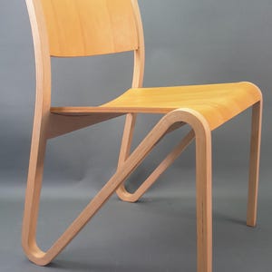 Può includere: Sedia in legno chiaro con schienale e seduta curvi. La sedia ha un design minimalista con gambe curve e schienale. L'indirizzo del sito web https://pulsantiques.etsy.com è visibile in basso nell'immagine.