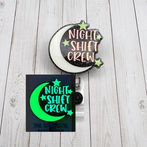 May include: A black and white glitter moon with the text "Night Shift Crew" in pink and green glitter. The moon is attached to a clear plastic badge holder with a black and white glitter circle charm. The badge holder is attached to a black and white glitter moon with the text "Night Shift Crew" in green glitter.