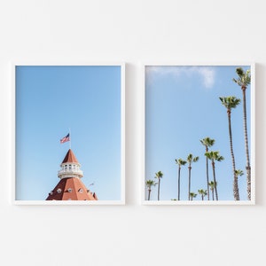 Puede incluir: Dos impresiones enmarcadas, una con un edificio de techo rojo con una torre blanca y una bandera estadounidense ondeando en la cima, y la otra con un cielo azul y palmeras sobre un fondo blanco.
