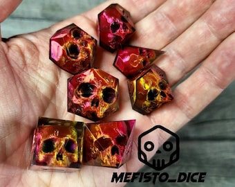 May include: Set of seven polyhedral dice with a skull design. The dice are translucent and have a red and yellow color scheme. The dice are made of resin and have a high-quality finish.
