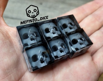 May include: Six black dice with a clear skull design and the number six on each side. The dice are in a hand, with the text "MEFISTO_DICE" visible in the background.