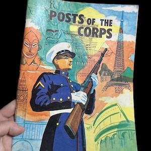 May include: Vintage book cover titled "Posts of the Corps" featuring a uniformed figure holding a rifle. The cover art includes illustrations of landmarks like the Eiffel Tower and Big Ben, with a colorful, retro aesthetic.