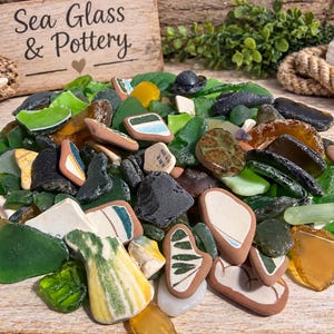 May include: A collection of assorted sea glass and pottery shards in various shades of green, brown, white, and yellow. The pieces feature smooth, weathered edges and some include decorative patterns, stripes, and textured surfaces.