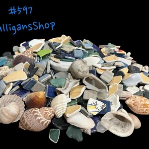 May include: A pile of colorful mosaic tiles, seashells, and broken pottery pieces. The pile includes blue, green, white, and yellow tiles, as well as seashells of various sizes and shapes. There is also a small porcelain doll head in the pile. #597 MulligansShop