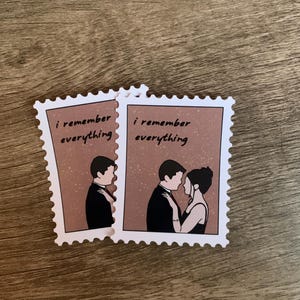 May include: Two stickers with a postage stamp design. Each sticker features a couple in formal attire, with the text "i remember everything". The background is a speckled brown.