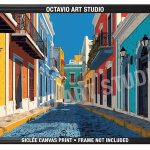 May include: A framed art print of a colorful street scene. Buildings in shades of orange, blue, and yellow line a cobblestone street under a clear blue sky. The artwork is labeled "OCTAVIO ART STUDIO" and "GICLEE CANVAS PRINT".