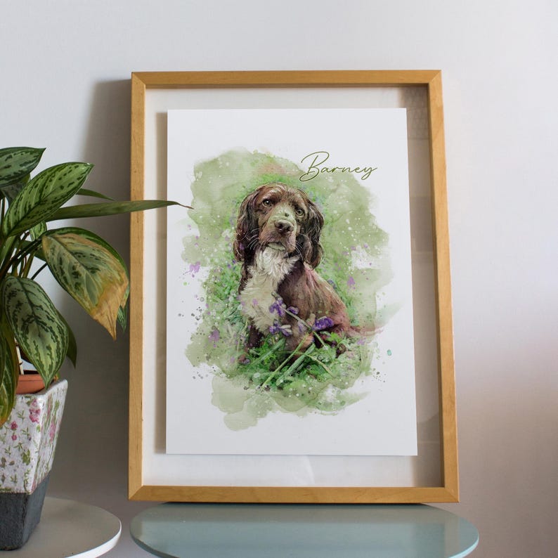Puede incluir: Una pintura de acuarela enmarcada de un perro marr&oacute;n y blanco llamado "Barney" sentado en un campo de hierba verde y flores moradas. La pintura tiene un efecto acuarela suave y est&aacute; colocada sobre un fondo blanco.