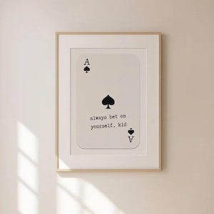 Puede incluir: Una impresi&oacute;n enmarcada de una carta de juego con el As de Picas. La carta tiene el texto "always bet on yourself, kid" impreso en ella.