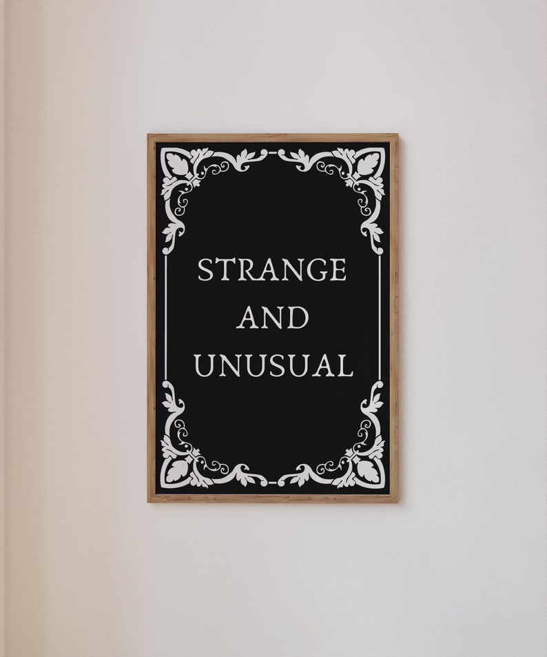 May include: Black and white framed print with a decorative border and the text "STRANGE AND UNUSUAL" in white.