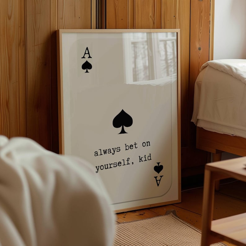 Puede incluir: Una impresi&oacute;n enmarcada de una carta de juego de as de picas con el texto "always bet on yourself, kid" impreso debajo de la carta.