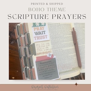 Puede incluir: Una Biblia abierta con pestañas decorativas en el borde, con notas adhesivas que contienen el texto PRAY WAIT TRUST, My sin was crucified with Jesus on the cross, y My Identity in Christ, acompañada de un bolígrafo marrón sobre la página.