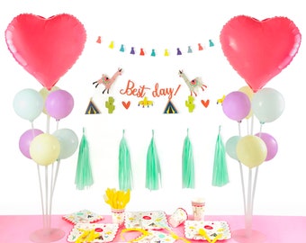 May include: A pink and white llama themed party decoration set with balloons, streamers, and paper plates. The balloons are arranged in a bouquet with a heart-shaped balloon at the top. The streamers are green and white and the paper plates have a llama design.