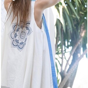 May include: White sleeveless top with a blue mandala design on the back. The top is made of a lightweight fabric and has a flowy silhouette.