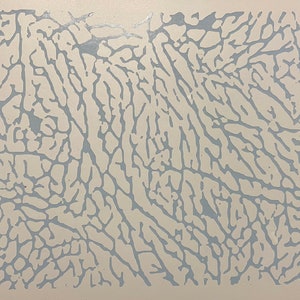 May include: A rectangular surface with a light beige background and a repeating pattern of light blue, vein-like shapes. The design resembles the texture of elephant skin or a topographical map.