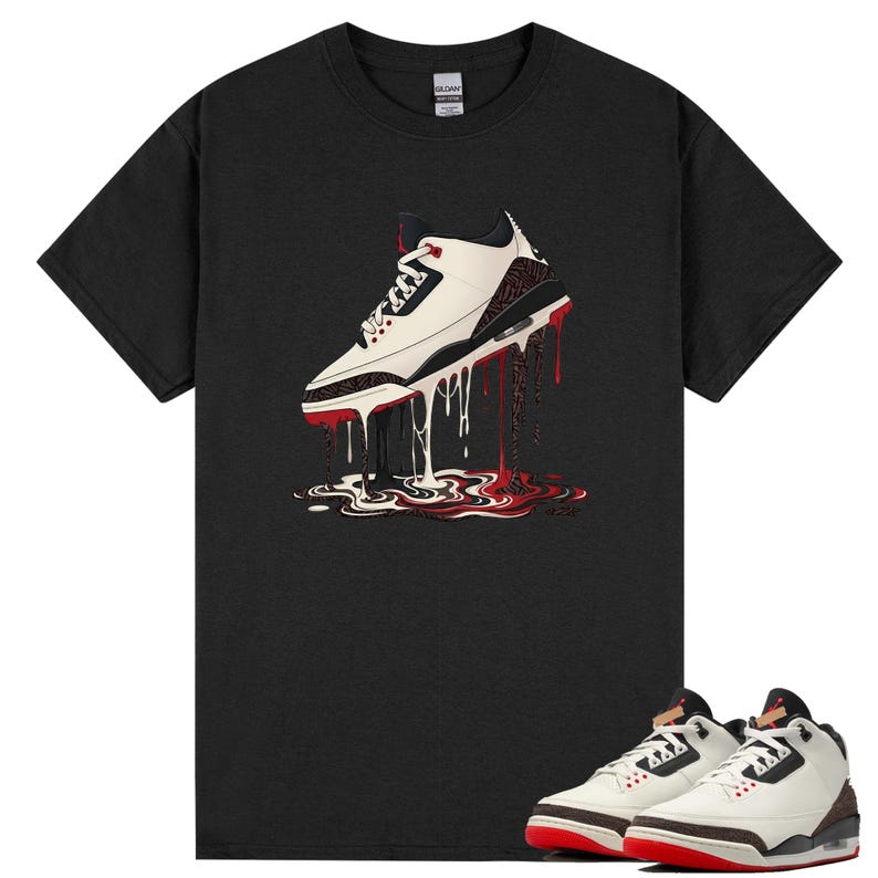May include: Black t-shirt with a graphic of a white and red sneaker with a dripping design. The image includes a pair of matching trainers at the bottom. The trainers have a white upper, red accents, and a black sole.