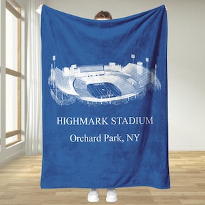 Può includere: Una coperta blu reale con un'illustrazione architettonica bianca dello stadio Highmark a Orchard Park, NY. Il design dello stadio è dettagliato, con il testo "HIGHMARK STADIUM" e "Orchard Park, NY" stampato sotto.