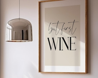 May include: A framed print with the text "but first WINE" hangs above a wooden desk. Two woven chairs are positioned in front of the desk. A window with a view of trees is visible.