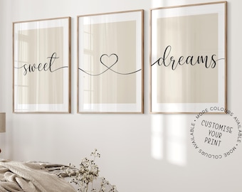 May include: Three framed prints with a beige background and black calligraphy. The prints read "sweet", "dreams", and a heart symbol. The prints are hanging on a white wall in a bedroom setting.