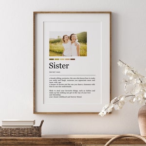 May include: A printable definition of the word "Sister" with a photo of two women smiling at each other. The definition describes a sister as a female sibling, protector, and someone who shares a closeness with you that no one else understands.
