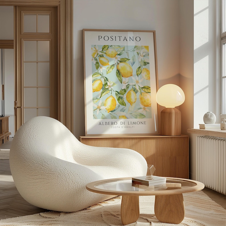 May include: A white, textured armchair sits in a living room with a wooden coffee table and a lamp. A framed print with a watercolor painting of lemons and the text "Positano, Albero di Limone, Costa d'Amalfi" hangs on the wall.