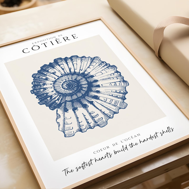 K&ouml;nnte beinhalten: Eine blaue und wei&szlig;e Illustration einer Muschel mit dem Text "Exposition de C&ocirc;ti&egrave;re" und "The softest hearts build the hardest shells Coeur de l'oc&eacute;an".