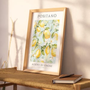 May include: A framed print with a watercolor illustration of a lemon tree with yellow lemons and white blossoms. The print has the text "Positano" at the top and "Albero di Limone Costa d'Amalfi" at the bottom.