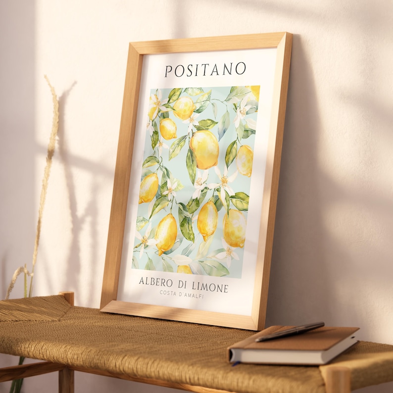 May include: A framed print with a watercolor illustration of a lemon tree with yellow lemons and white blossoms. The print has the text "Positano" at the top and "Albero di Limone Costa d'Amalfi" at the bottom.