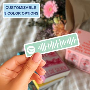 May include: A rectangular sticker featuring a light green background with a white Spotify logo and a white sound wave graphic. The sticker includes text that reads CUSTOMIZABLE 9 COLOR OPTIONS. The design is presented as a flat, adhesive label.