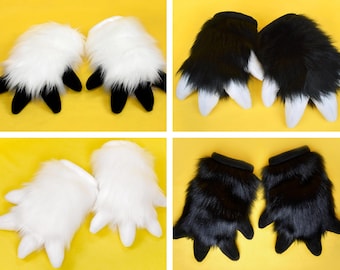 May include: Four pairs of furry paw gloves in the image. Two pairs are white with black claws, and two pairs are black with white claws. The gloves have a plush texture and are set against a yellow background.